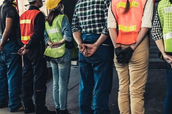 equipo de trabajadores de la construccion de espaldas posan en fila